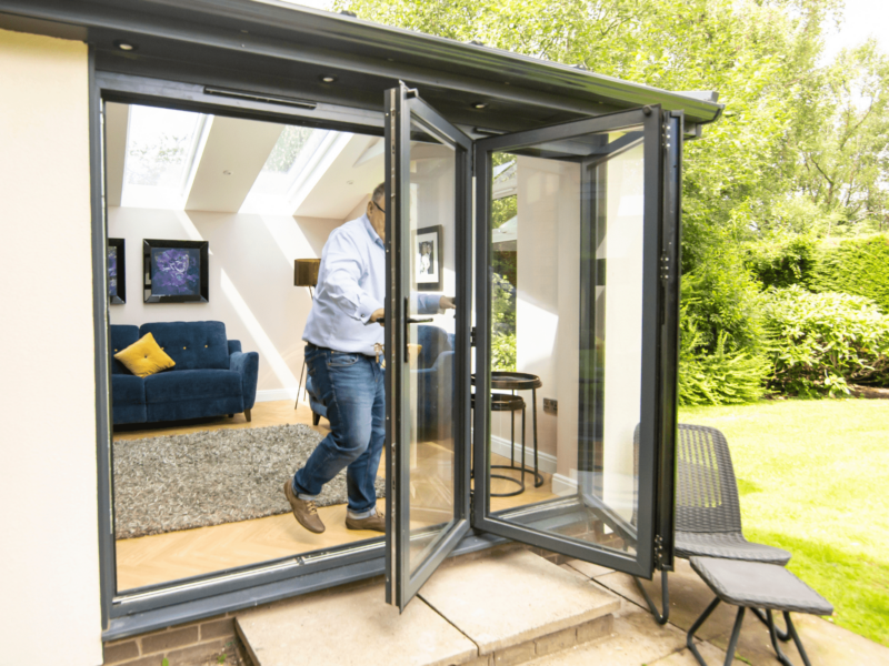 man opening bifold doors in a hup! extension